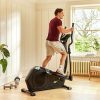 Person på en crosstrainer i stuen