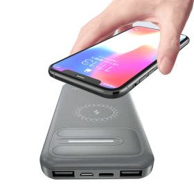 En hånd holder en smartphone over en hvid Powerbank Wireless Pro 10.000mAh med flere porte.