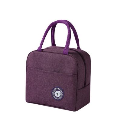 Lille, lilla køletaske med to håndtag og en forside-lomme. Har et rundt mærke med en bjørn og teksten "Lunch Bag".