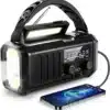 Sort radio powerbank med solceller, lommelygte og håndtag. Forbundet til en opladende smartphone.
