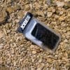 Vandtæt mobilcover med en mobiltelefon på sten.