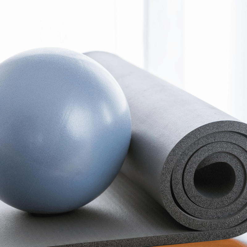 En blå bold og en grå yogamåtte.