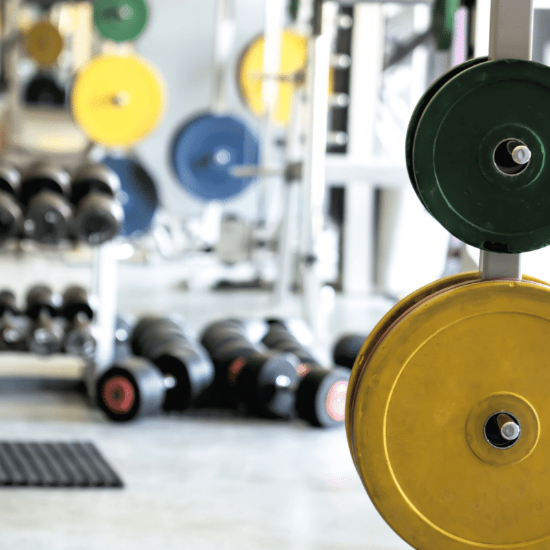 Vægtskiver og håndvægte i et fitnesscenter.