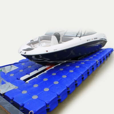 Båd Platform En hvid speedbåd er placeret på en blå, flydende platform med moduler, der danner en stabil base på vandet.