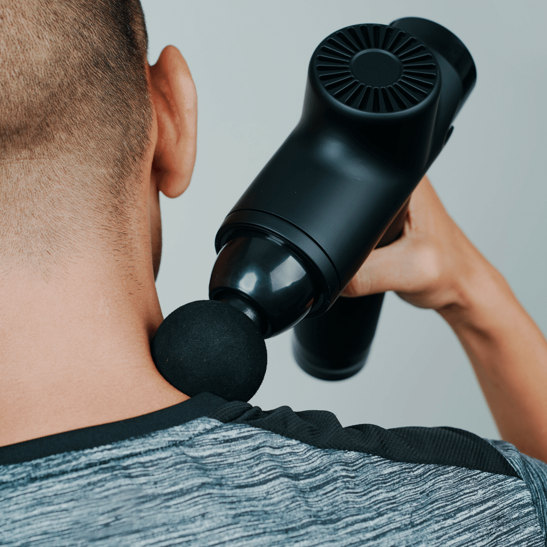 Person bruger en massagepistol på nakken.
