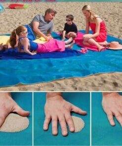 Familie sidder på et sandfrit tæppe på stranden.