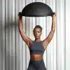 Person holder en BOSU-bold over hovedet.