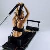 Kvinde udfører øvelse på Pilates-reformer