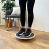 Person balancerer på et balancebræt indendørs.