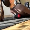 Kvinde ligger på foam roller på yogamåtte