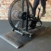 Nærbillede af motionscykel med ventilatorhjul og træningsmåtte