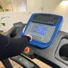 Person bruger løbebåndets kontrolpanel