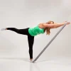 Kvinde træner med elastik i en balanceposition.