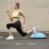 Kvinde laver lunges med en bosu bold.