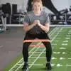 Kvinde træner med et orange modstandsbånd.