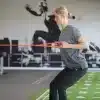 Kvinde træner med elastikbånd i fitnesscenter.