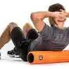 Person bruger en orange foam roller.