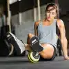 Kvinde masserer sit ben med en foam roller.