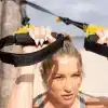 Kvinde holder TRX-stropper udenfor