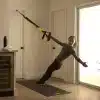 Kvinde udfører øvelse med TRX-stropper i hjemmet.