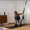 Kvinde laver øvelse med TRX-stropper indendørs