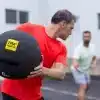 Mand holder en TRX medicinbold udendørs.