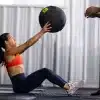 Kvinde i fitnesscenter holder medicinbold