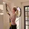 Kvinde installerer TRX strop på en dør.