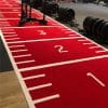 Rød løbebane med nummerering i fitnesscenter.
