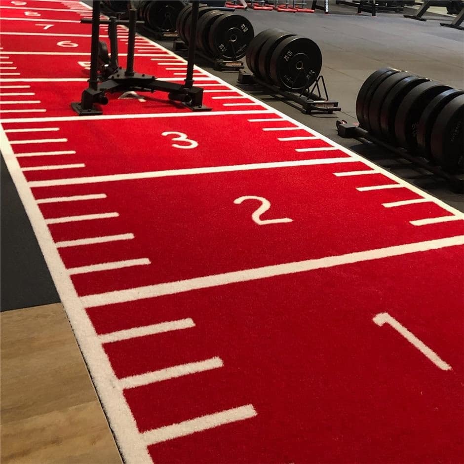 Rød løbebane med nummerering i fitnesscenter.