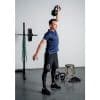 Mand løfter kettlebell i træningscenter