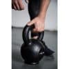 Hånd griber om en sort kettlebell