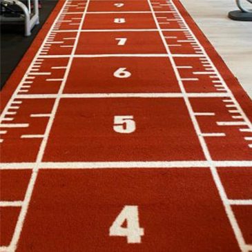 Rød numereret løbebane i et fitnesscenter.